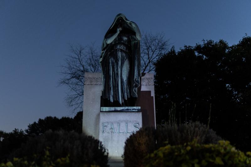 monument of woman in shroud at cemetery