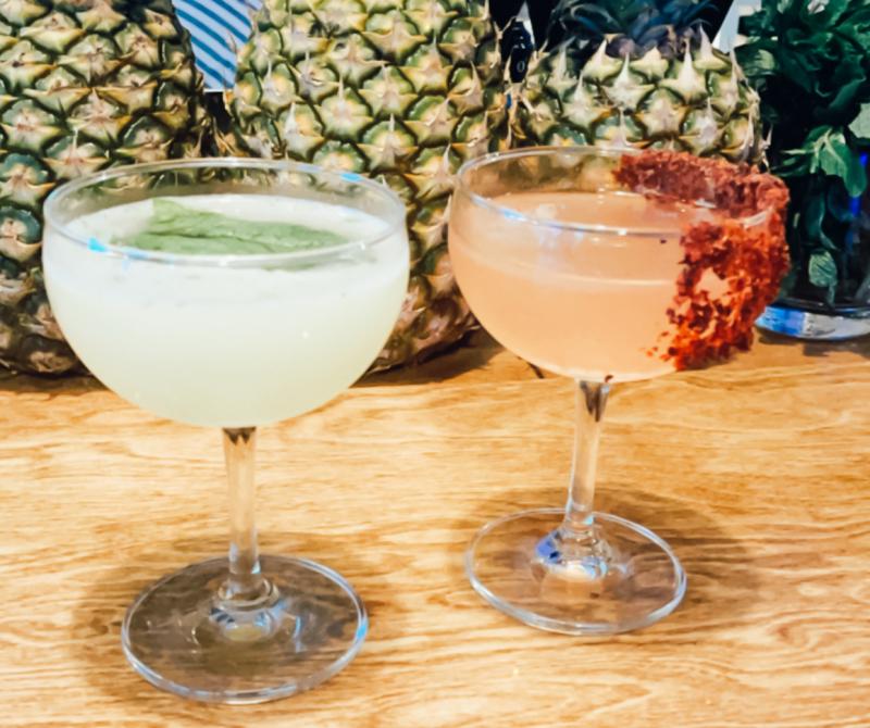 two drinks in front of pineapples