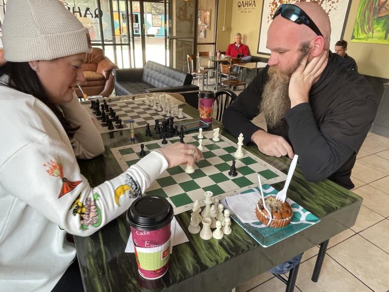 people playing chess at a coffee shop downtown