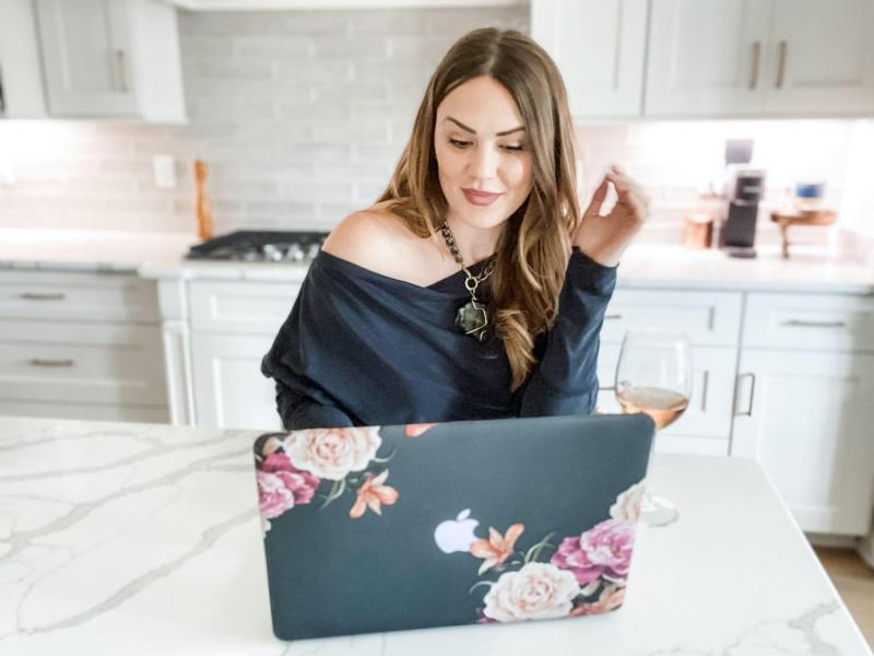 girl looking at laptop in white kitchen