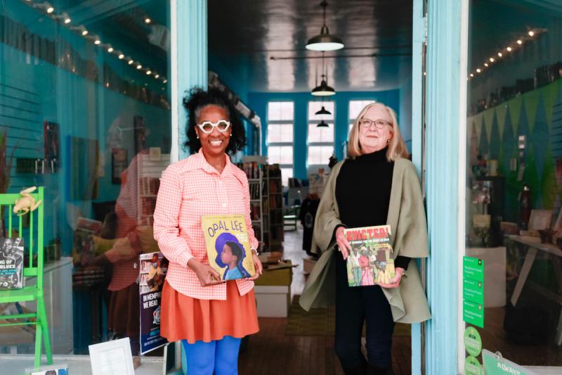 two women standing in front of bookstore