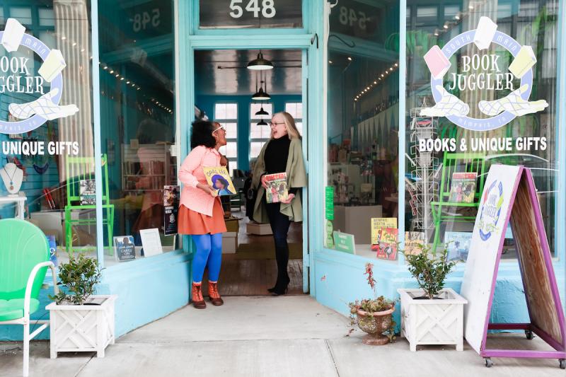 two women standing in front of bookstore