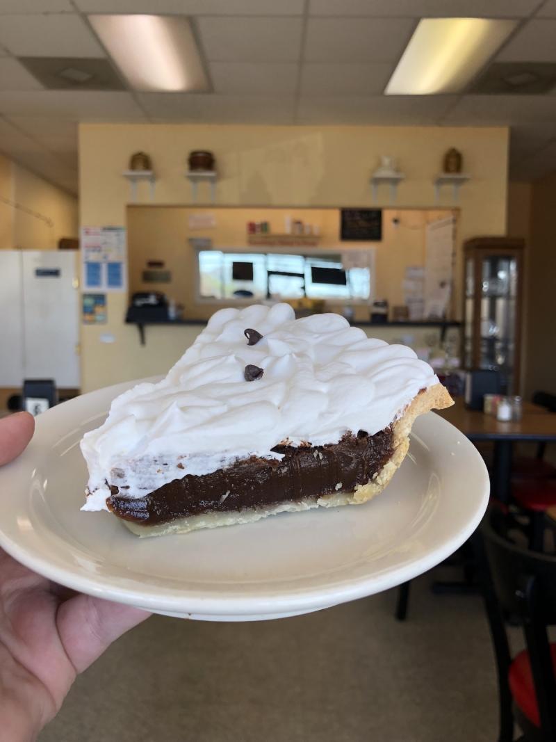 chocolate pie with whipped cream on top in a homey pie shop
