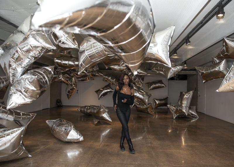 girl standing in metallic baloon exhibit