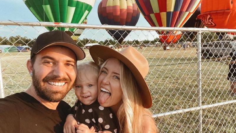 family in front of hot air balloons