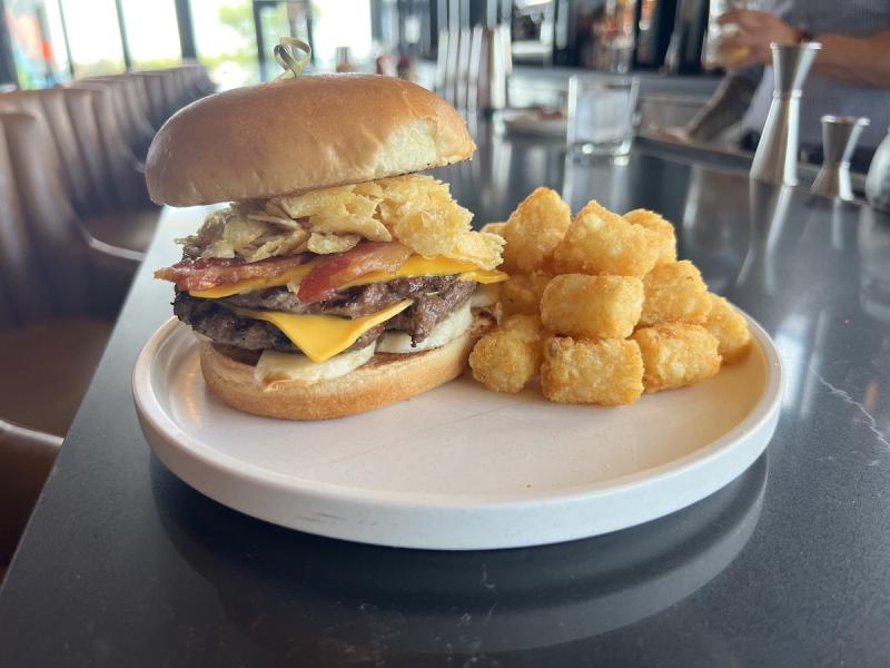 burger and tater tots sitting on a bar