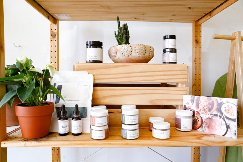 wooden shelf with body products in jars and a plant