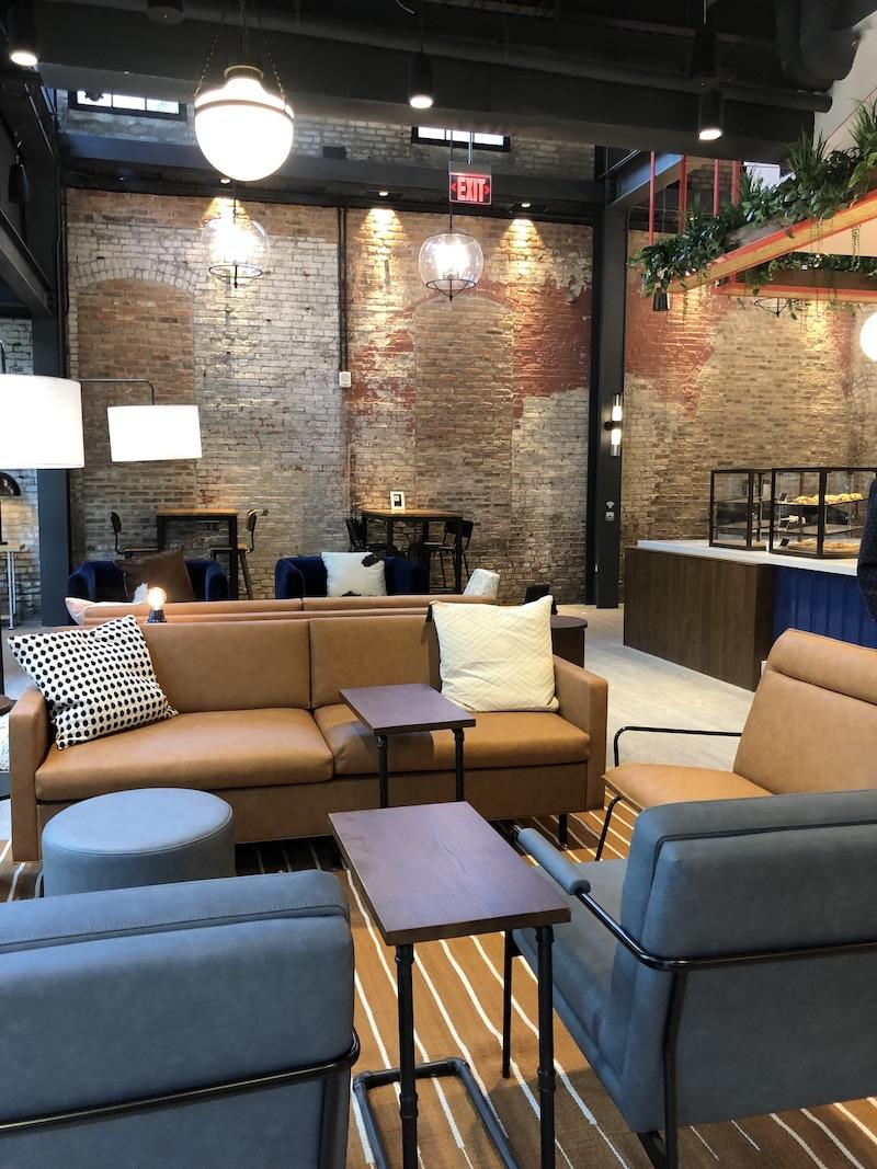 hotel lobby with brown leather couches and gray soft chairs