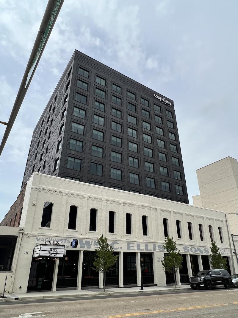 tall black building in front of shorter white brick facade