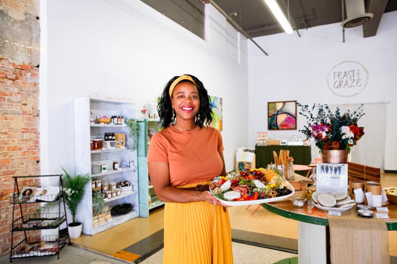 woman holding a charcuterie board in a cafe