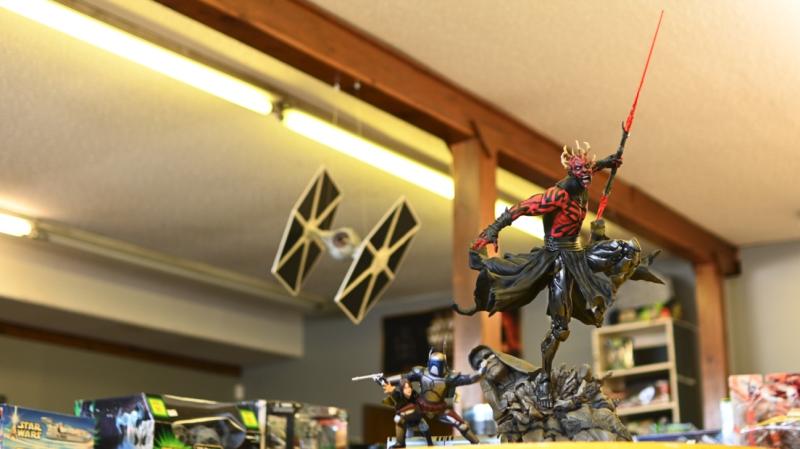 Star Wars toys on a top shelf, including the character Darth Maul