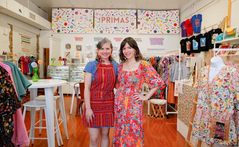 Two women standing in brightly lit shop