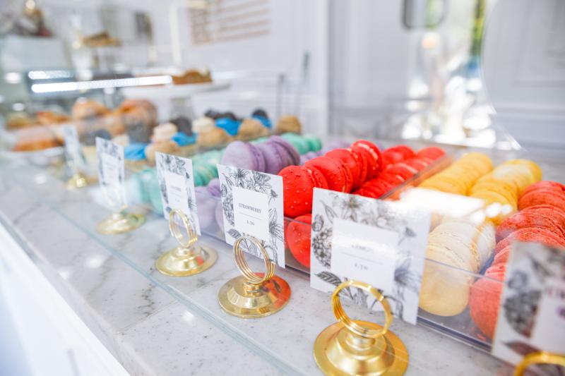 Multi-colored macaroons sit on a display shelf