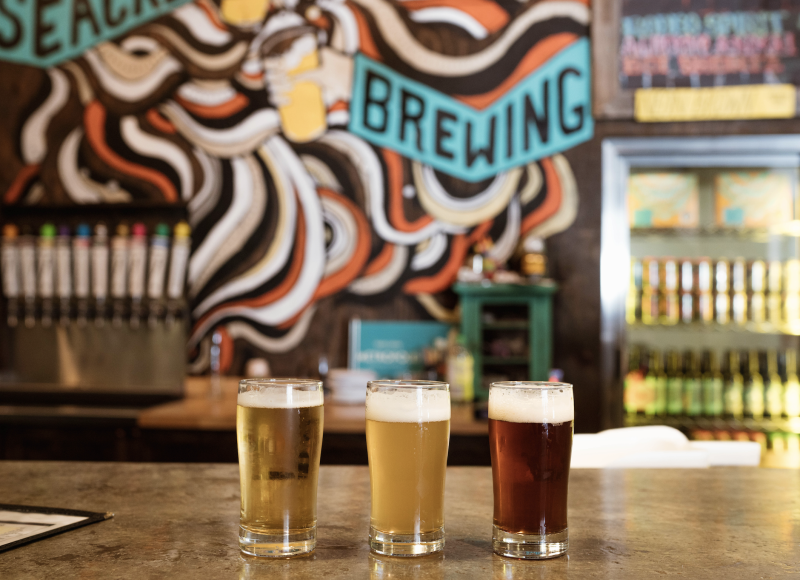 three sample beers sit on wiseacre counter in front of taps