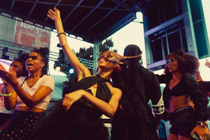 A group dancing and cheering on performers at Tone Juneteenth Gala