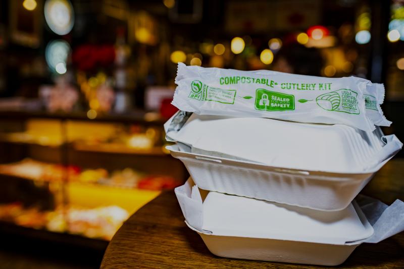 two compostable to-go boxes with compostable silverware on top