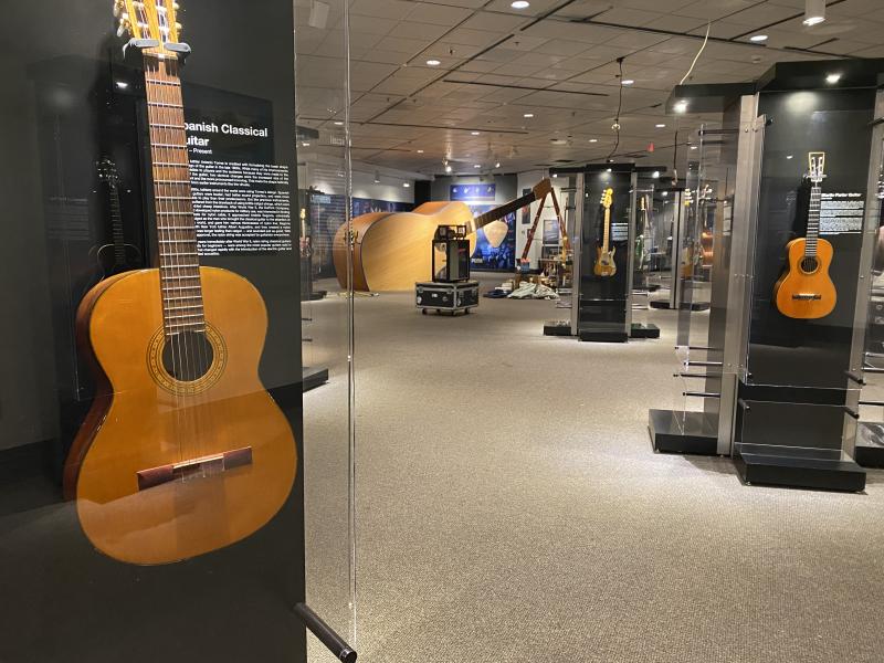 close up of guitar with exhibit in background