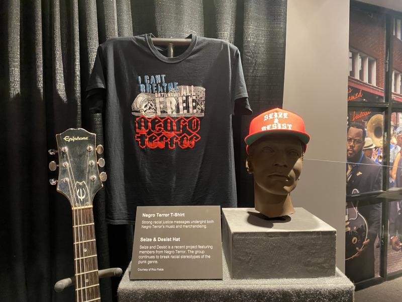 negro terror display with shirt, guitar and hat