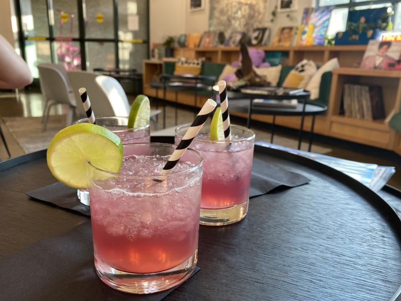 three cocktails sitting on table with moxy lobby in background