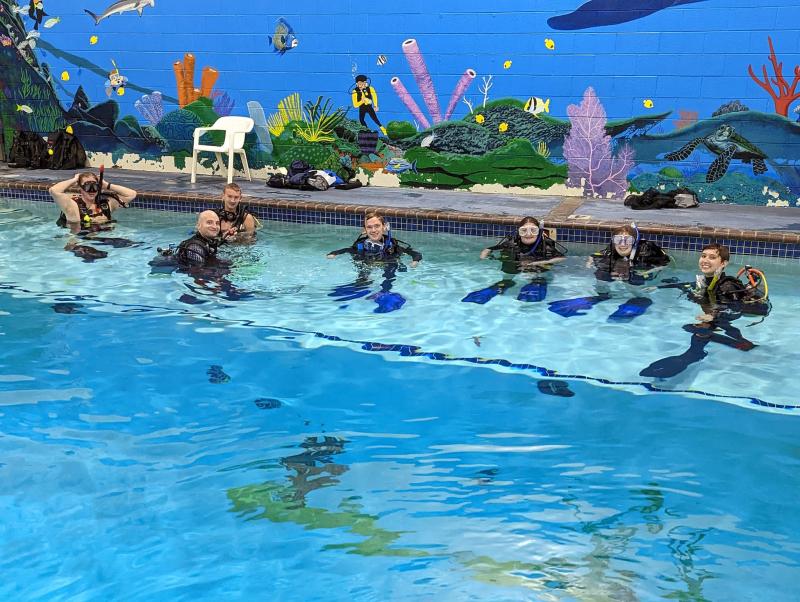 scuba divers training pose for photo in water