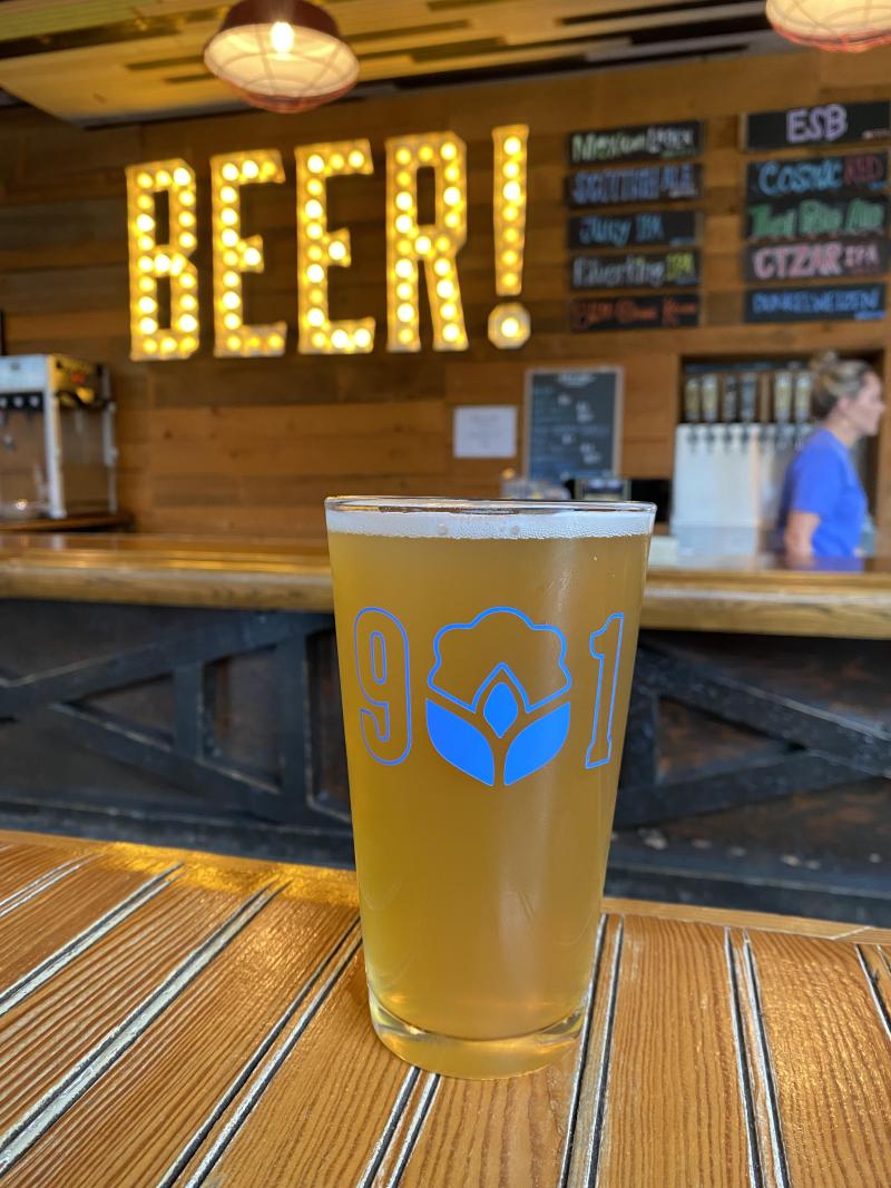 beer sitting in front of neon BEER! sign