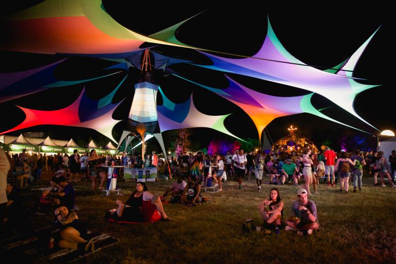 Festivalgoers under a colorful canopy at Mempho Music Festival.