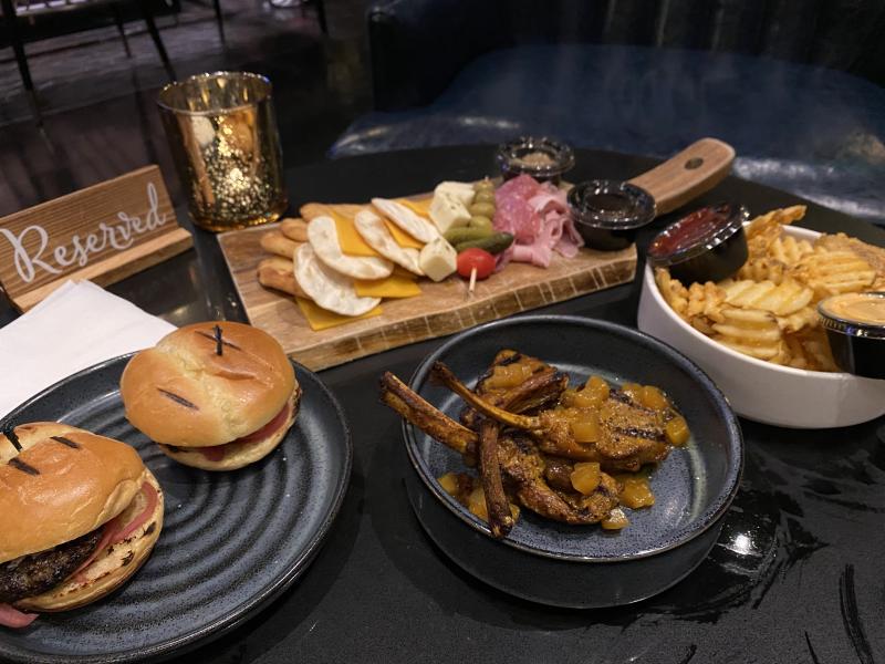 spread of food from beck &amp; call: sliders, lamb chops, cheese board, and waffle fries