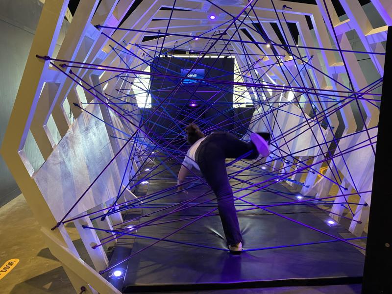 woman crawls through net of wires