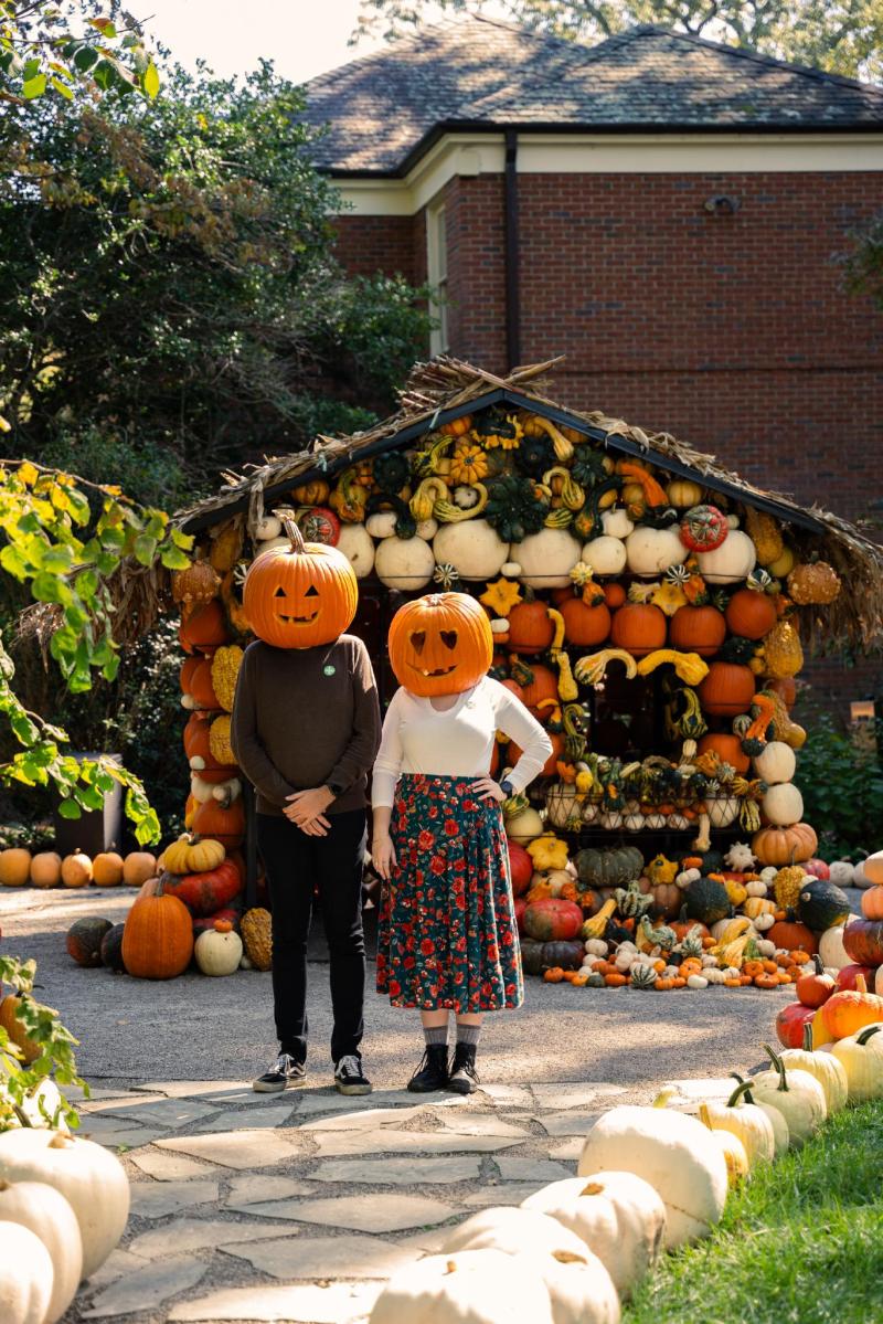 pumpkin head models stand outside pumpkin house