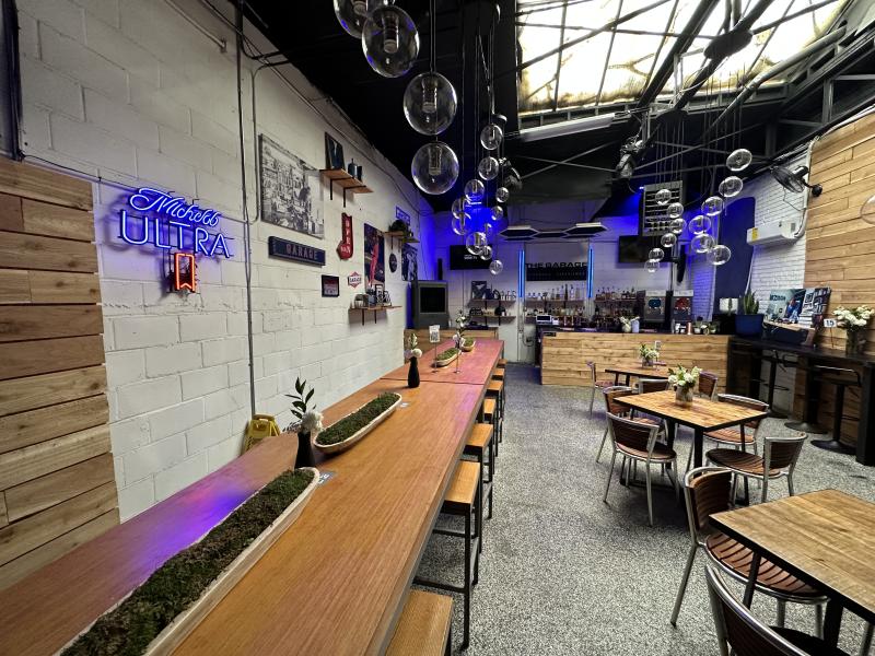 inside the garage expansion of genre restaurant with long tables, bar and more
