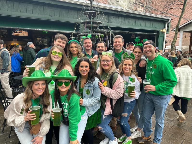 group of people pose for photo decked out in green for st. Patrick's day