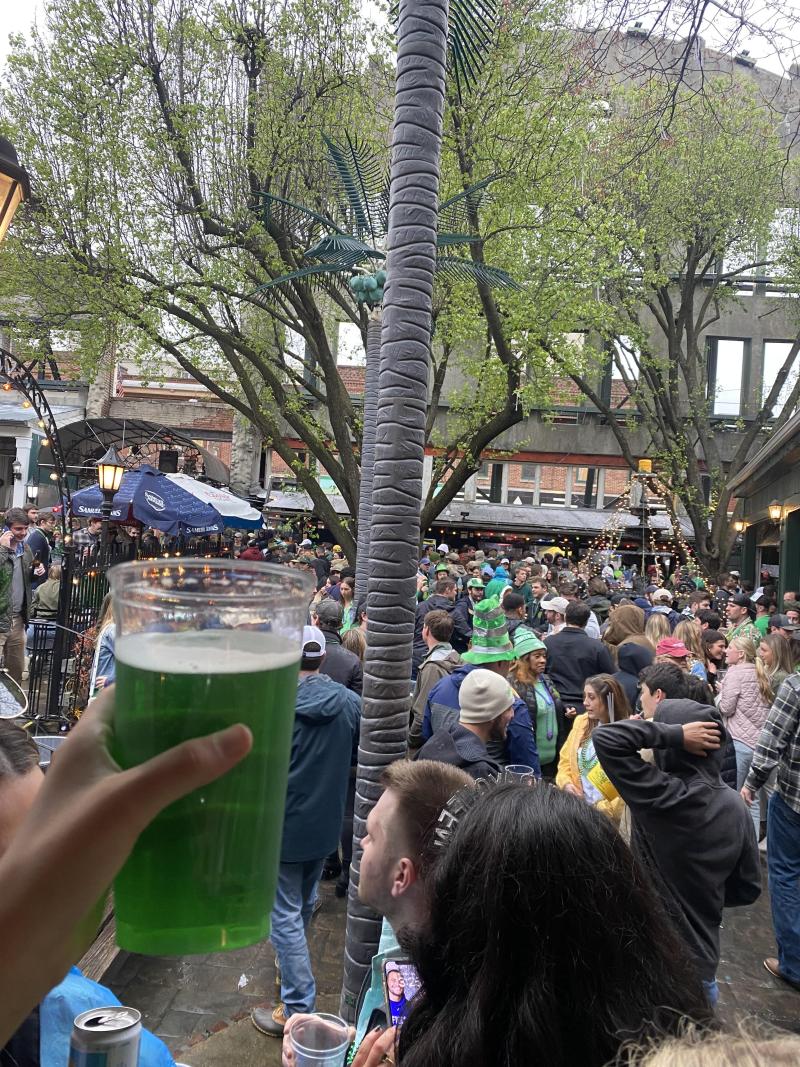 green beer held up in front of packed patio at silky o' Sullivans on st Patrick's day