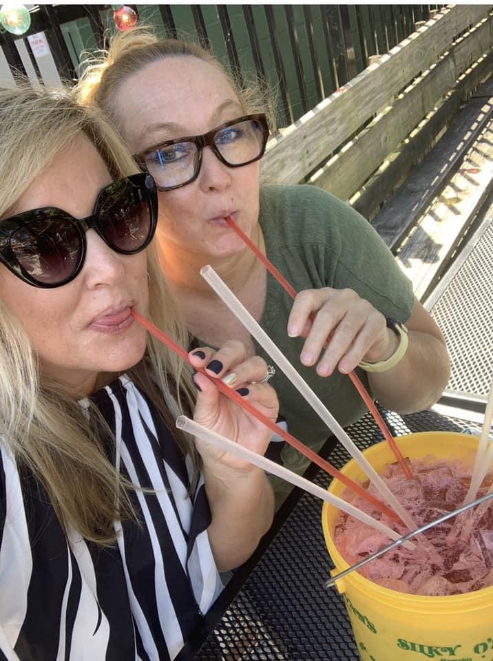 two women drink from diver bucket