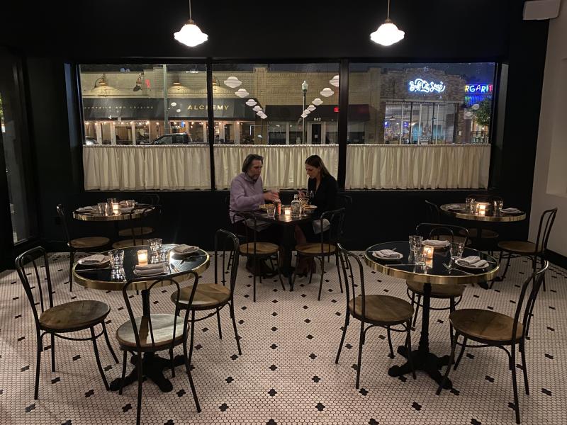 dining area of small tables. one couple eating