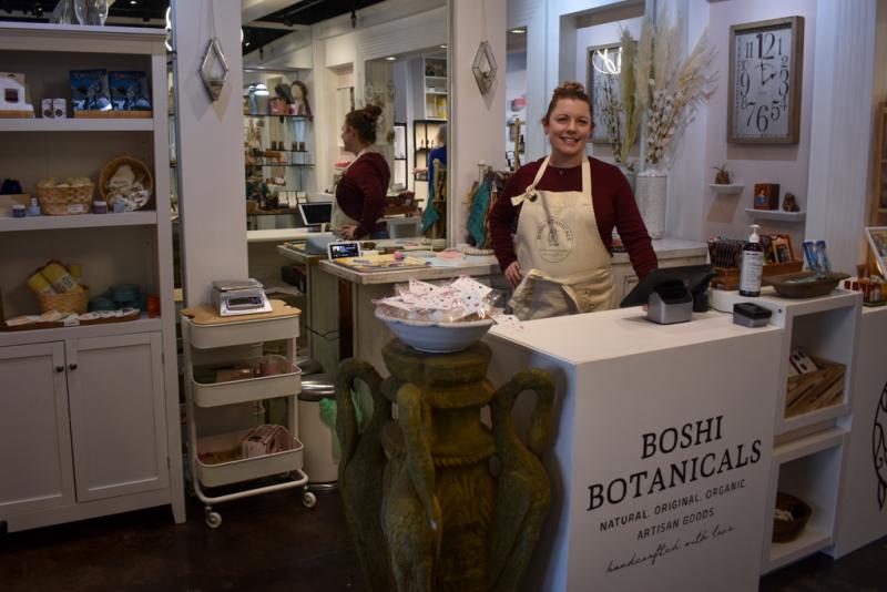 Boshi Botanicals owner poses at counter for photo