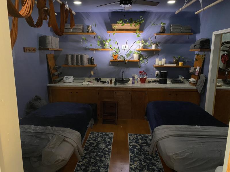 two massage beds and shelves in dimly lit room