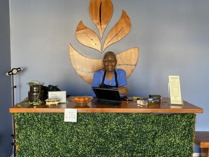 owner Emma crystal smiles for photo behind front desk