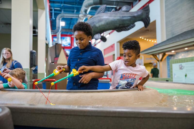 two young boys play with CMOM water exhibit