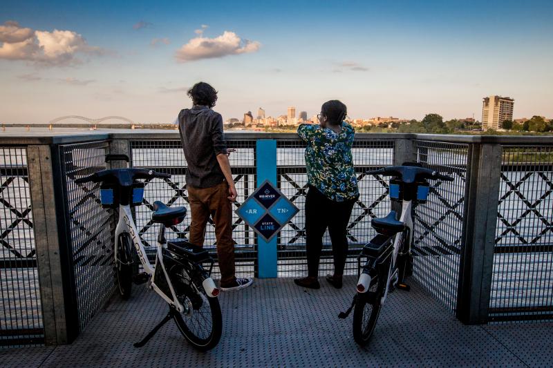 two bikers stop to view the memphis skyline from big river crossing