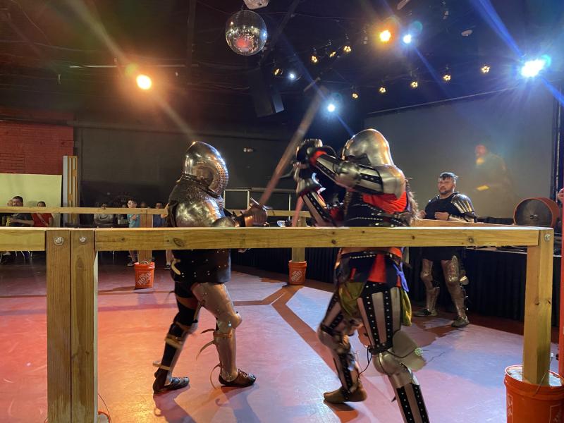 two people dressed in knight armor battle