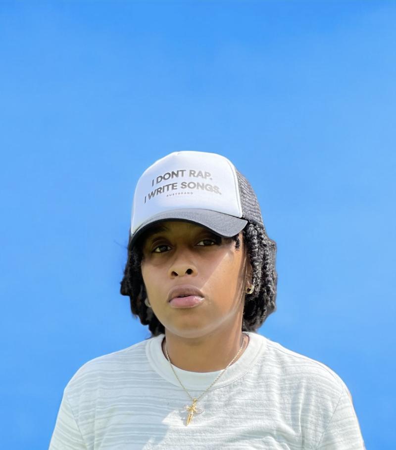 portrait of artist jus Bentley who wears a hat saying "I don't rap. I write songs."