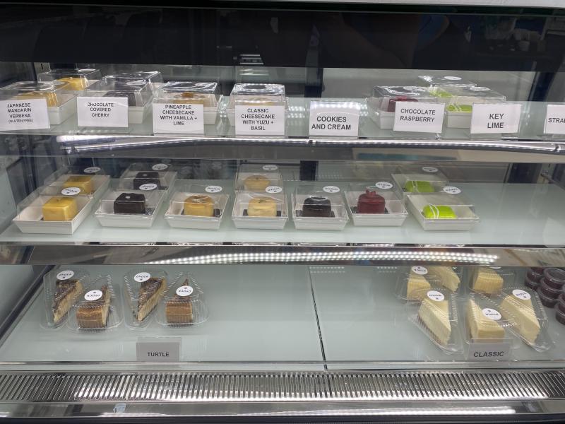 case of cheesecakes mini and slices on display at dvour