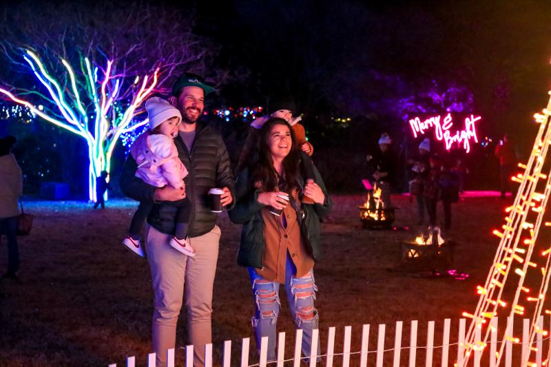 family smiles looking at holiday lights