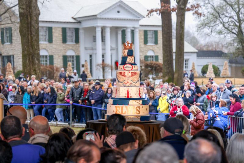 elvis birthday celebration with people crowding around a huge birthday cake at graceland