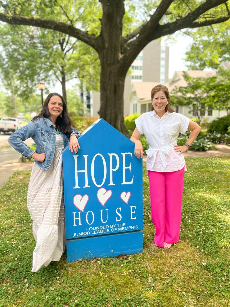 two ladies standing by hope house sign