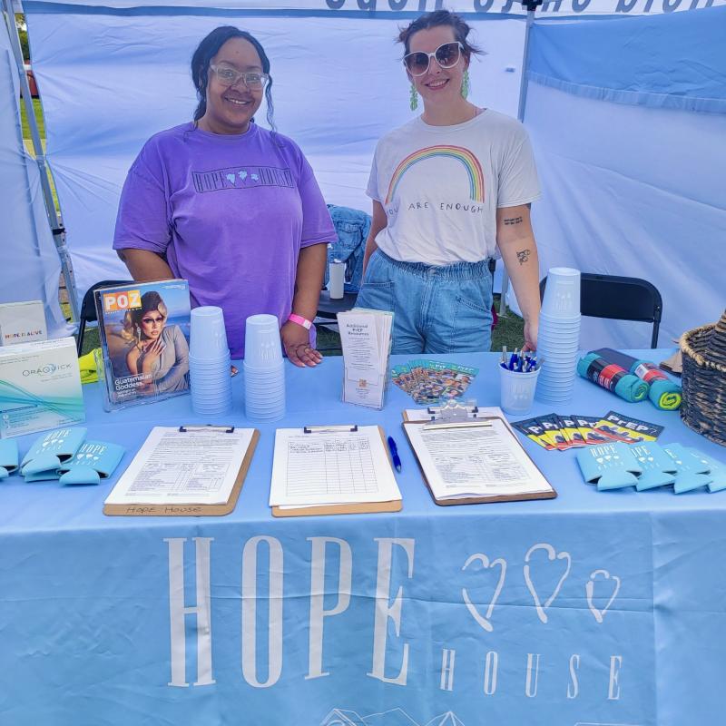 two women standing behind hope house table
