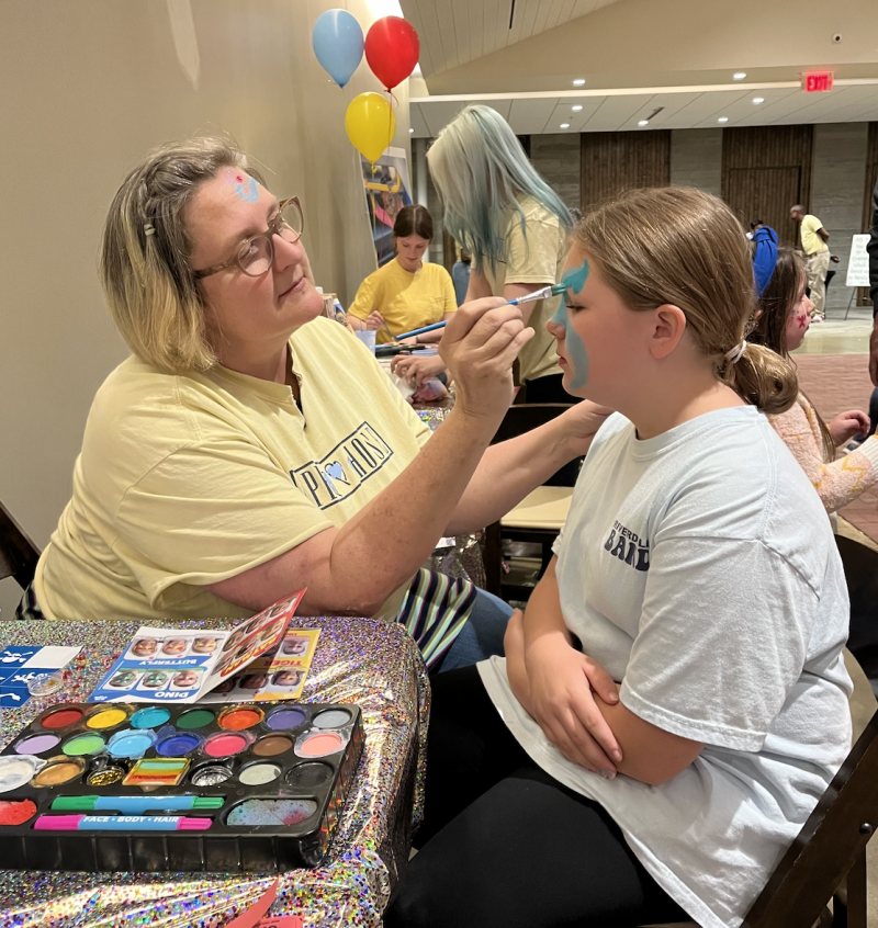woman face painting young girl