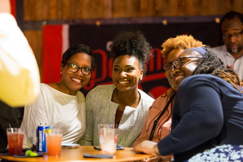 Three women smile for photo at Old Dominick