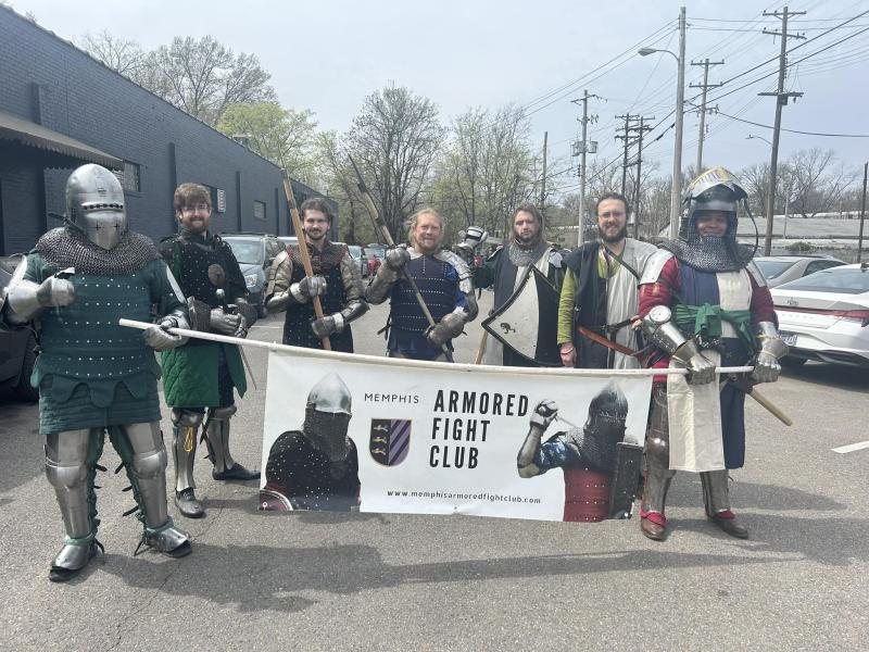 armored fight club team poses for photo in knight armor and club sign