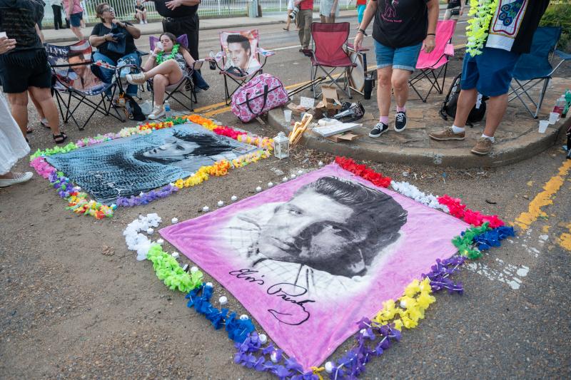 two elvis blankets sprawled out on ground at candlelight vigil